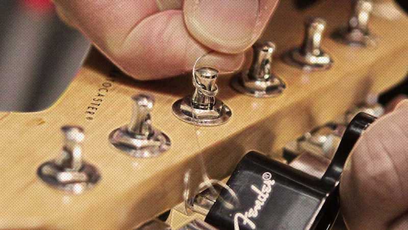 Step-by-step demonstration of changing electric guitar strings.