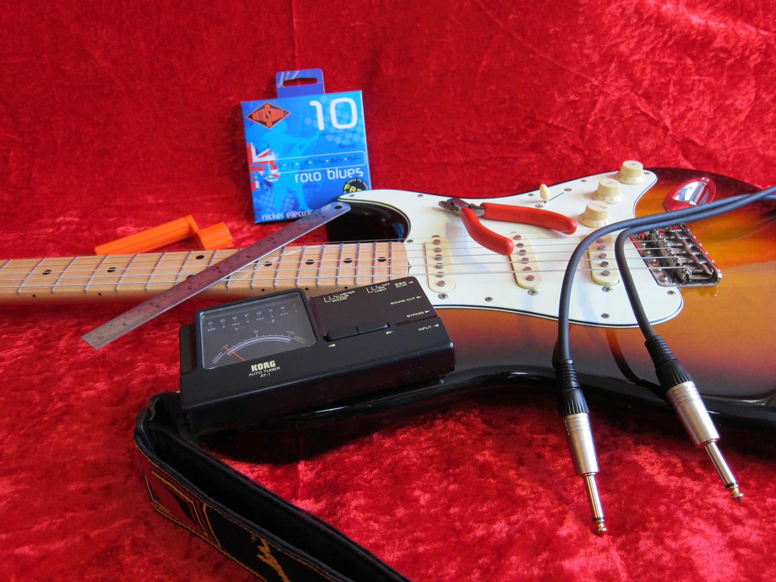 Starting the string changing process on a vintage-style Stratocaster guitar.