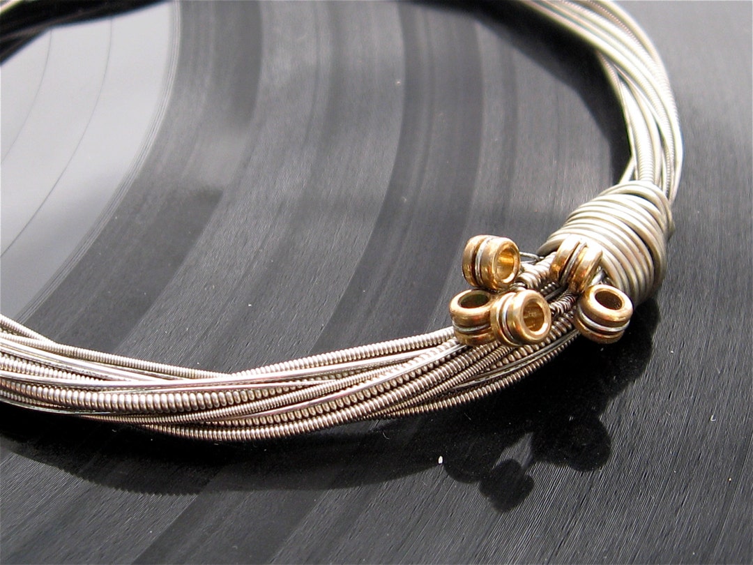Personalized guitar string jewelry as an example of balancing sentiment and practicality.