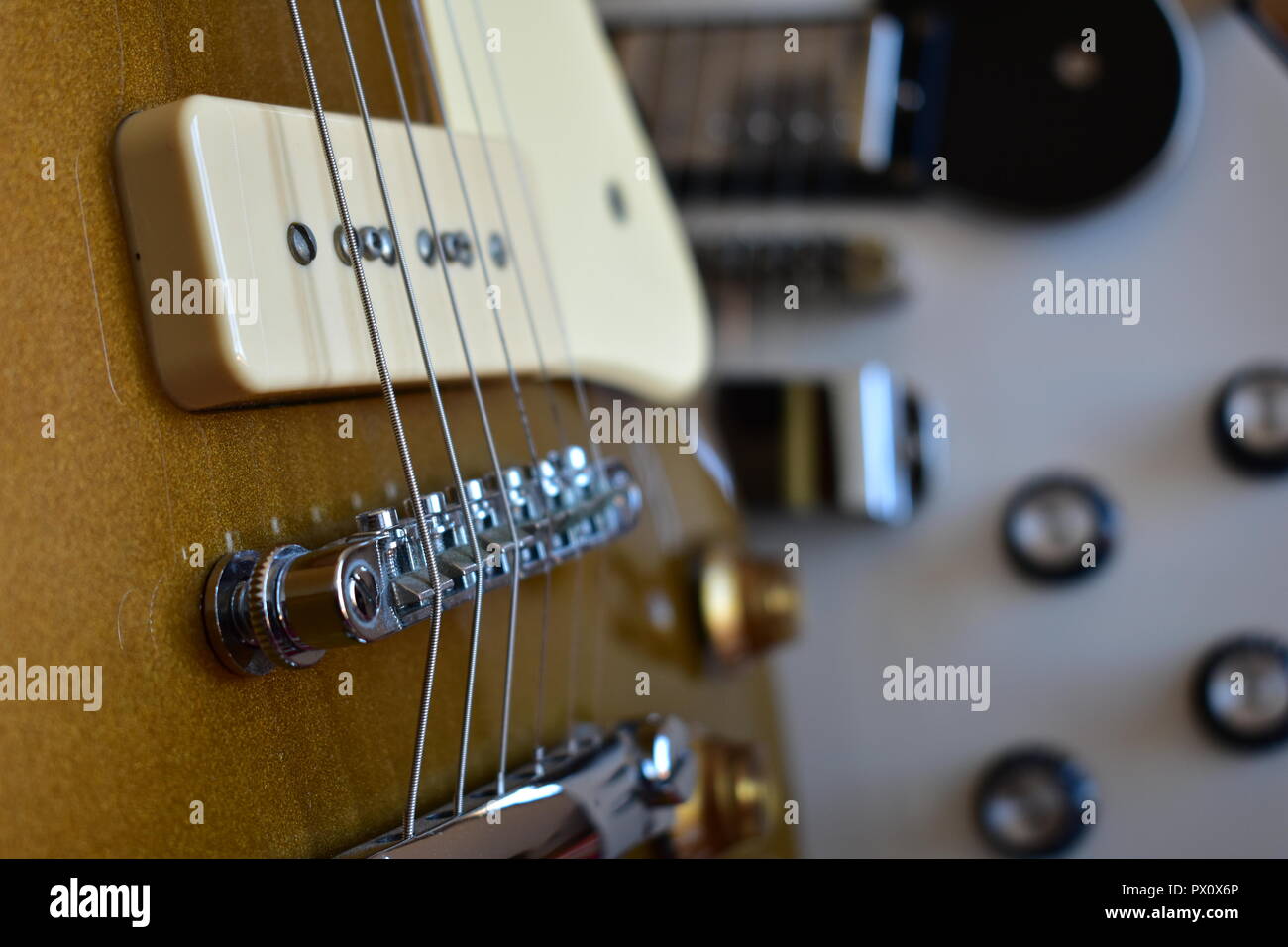 Close-up comparison of P90 and humbucker pickups on Les Paul style guitars.