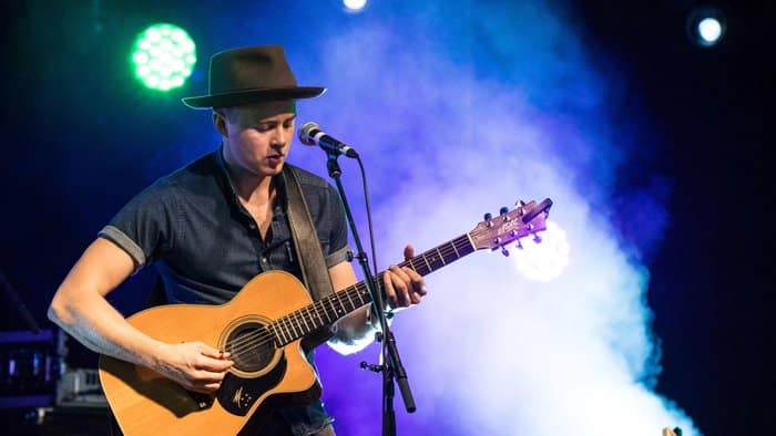 Joe Robinson performing, a guitarist known for his fingerstyle technique, which relates to genre-specific musicians.